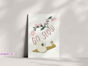 Whimsical snail illustration with a heart shell, pink flowers, and handlettered “Go Slow” text.